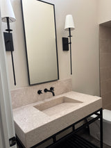 Bathroom vanity with marble top, ramp-style sink, and metal base