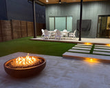 Round concrete fire pit table with a modern bowl design, compatible with propane and natural gas – luxury outdoor centerpiece.
