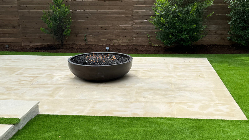 Round concrete fire pit table with a modern bowl design, compatible with propane and natural gas – luxury outdoor centerpiece.
